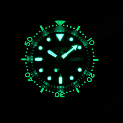 Glowing green watch face on a black background