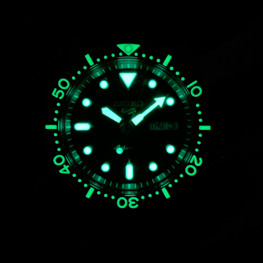 Glowing green watch face on a black background